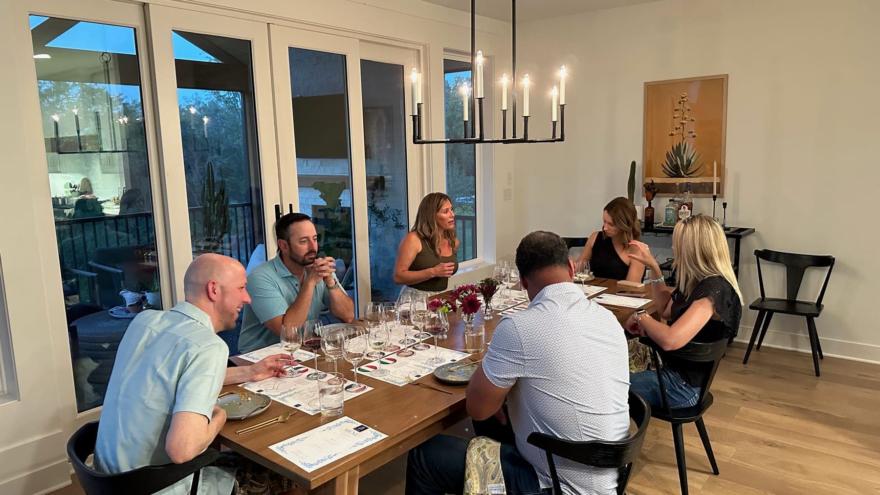 Hannah stands mid-story as six guests taste through their flights at a candlelit table